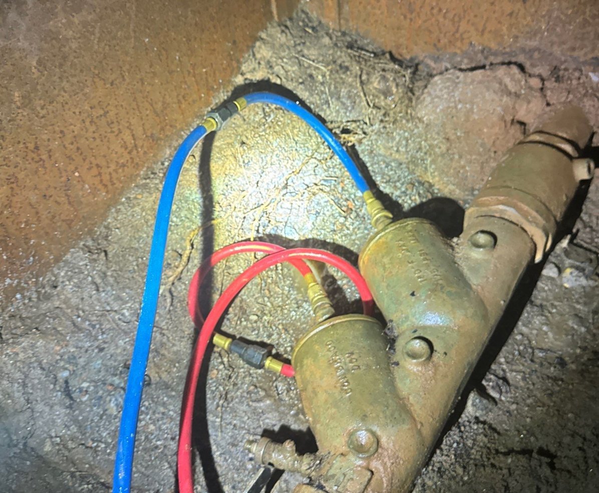 Backflows-preventer assembly in a vault in the ground with test hoses attached.